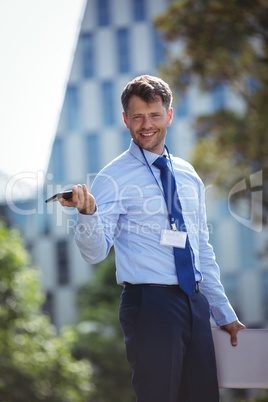 Handsome businessman holding mobile phone and laptop