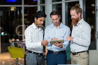 Businessmen discussing over digital tablet