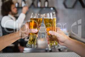 Two men toasting a glass of beer