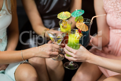 Female friends toasting glasses of cocktail in bar