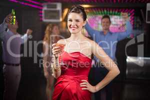 Portrait of young woman holding a glass of cocktail