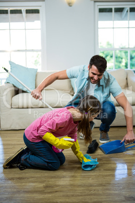 Daughter helping father to clean floor