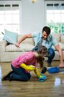 Daughter helping father to clean floor