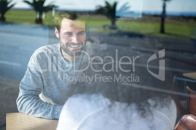 Man talking to a woman in coffee shop