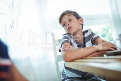 Thoughtful boy sitting on chair