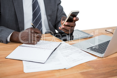 Mid section of businessman using phone and other multimedia devices