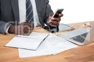 Mid section of businessman using phone and other multimedia devices