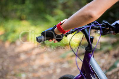 Female athletic standing with mountain bike in park