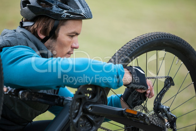 Male mountain biker fixing his bike chain