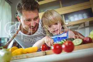 Father and daughter chopping vegetables in kitchen