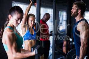 Friends lifting dumbbells while working out