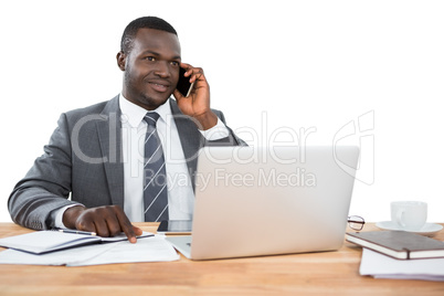 Businessman talking on the phone and using other multimedia devices