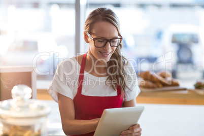 Waitress sitting at table and using digital tablet in cafÃ?Â©