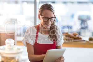 Waitress sitting at table and using digital tablet in cafÃ?Â©