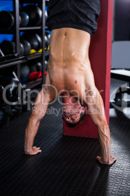 Shirtless athlete doing handstand