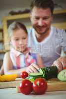Father and daughter chopping vegetables in kitchen