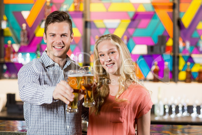 Couple showing a glass of beer in bar