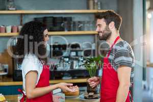 Waiter and waitress interacting with each other in cafÃ?Â©