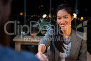 Businesswoman shaking hands with colleague