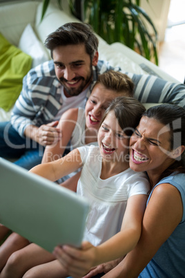 Happy family using digital tablet in the living room