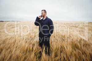 Farmer talking on mobile phone in the field