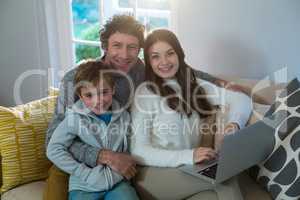 Family using laptop on sofa