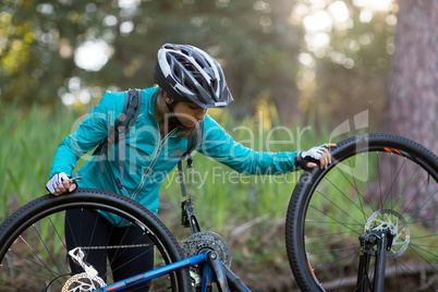 Female biker repairing mountain bike