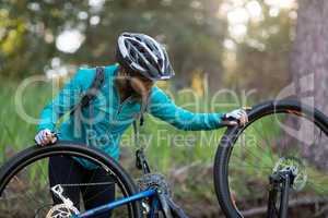 Female biker repairing mountain bike