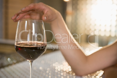 Woman having red wine at bar counter