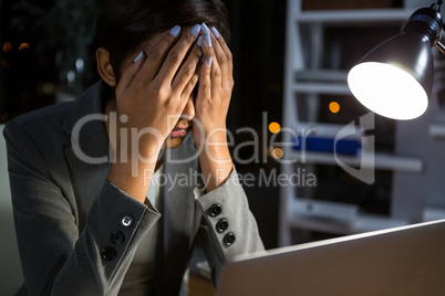 Stressed businesswoman sitting at her desk