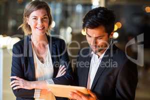 Businessman discussing with colleague over digital tablet