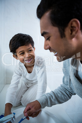 Father and son brushing teeth in the bathroom