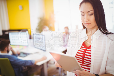 Confident businesswoman using digital tablet at creative office