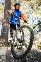 Male mountain biker riding bicycle in the forest