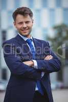 Portrait of handsome businessman standing with arms crossed