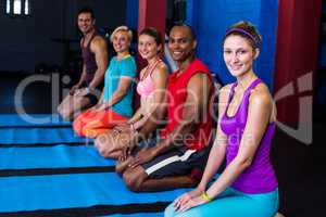 Portrait of smiling people kneeling in gym