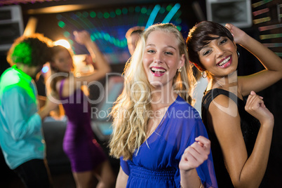 Two beautiful women dancing on dance floor