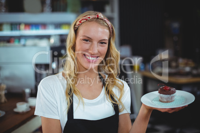 Portrait of waitress holding a plate of cupcake