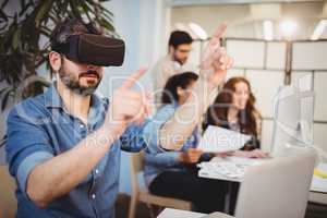 Creative businessman gesturing while using virtual reality headset