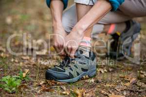 Female hiker tying shoelaces