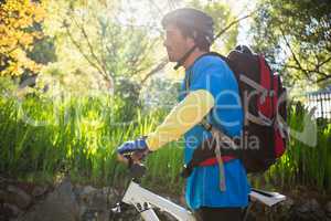 Male mountain biker with bicycle in the forest