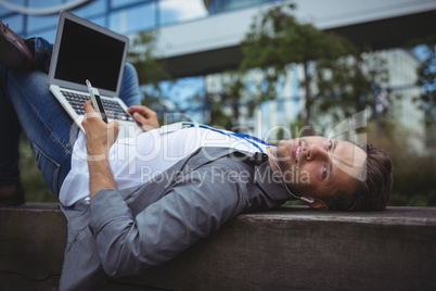Portrait of business executive listening music on mobile phone