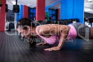 Side view of athlete woman doing push-ups