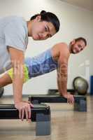 Portrait of two men doing aerobic exercise on stepper