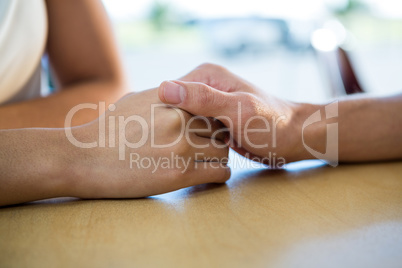 Couple holding hands in coffee shop