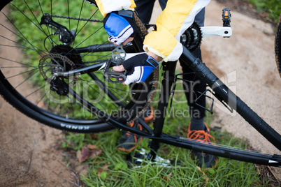 Low section of male biker repairing mountain bike