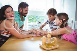 Parents and kids putting their hands together on table