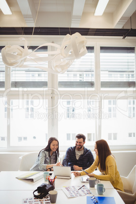 Business people using laptop in meeting room