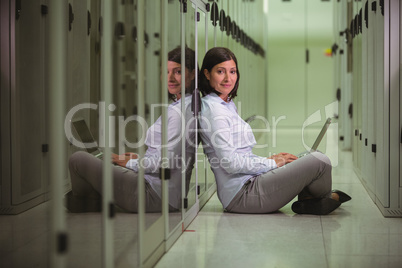 Portrait of technician siting on floor and using laptop