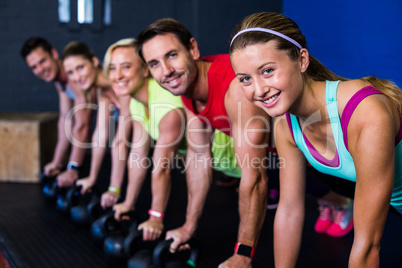 Smiling athletes exercising with kettlebells